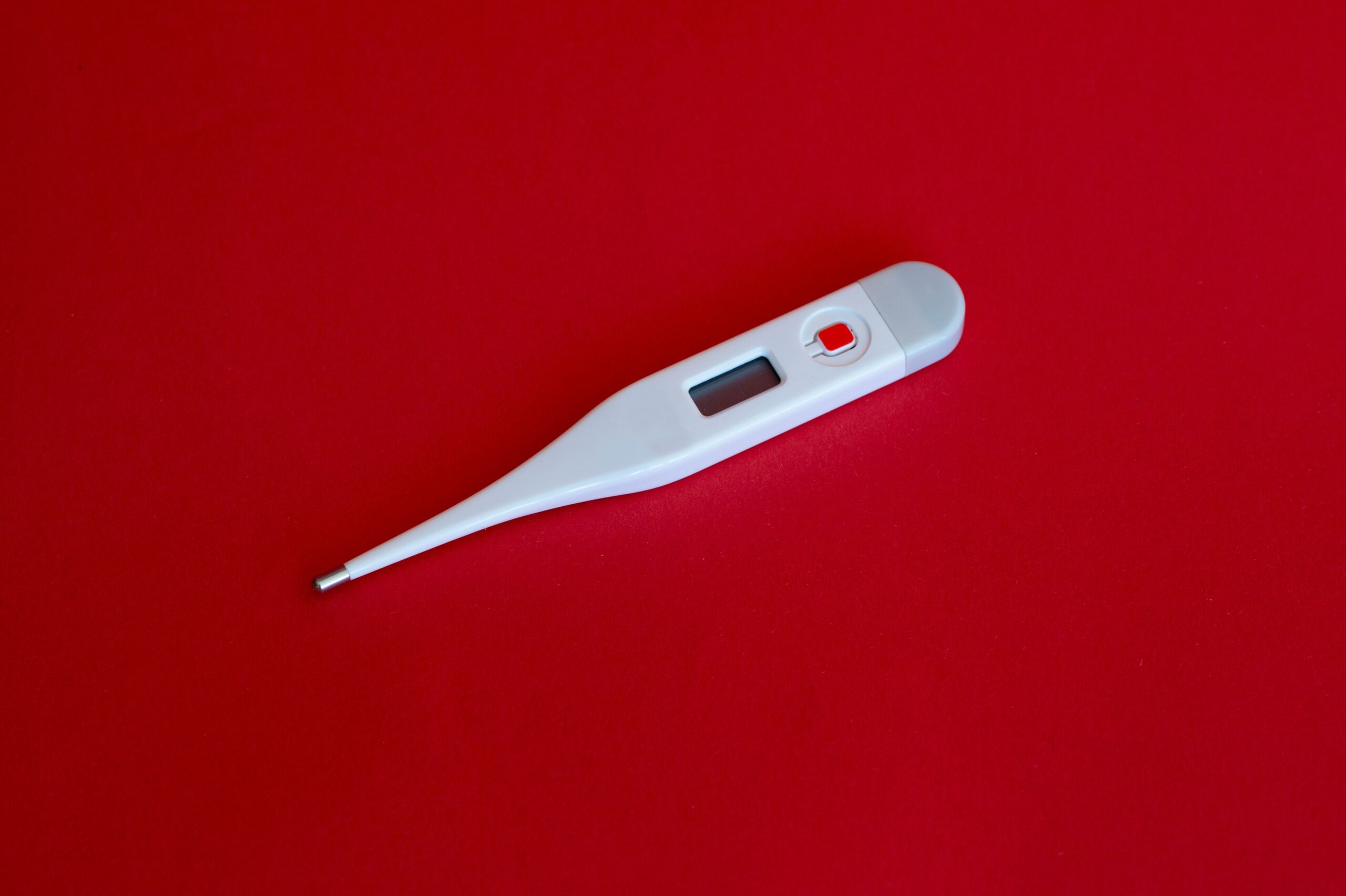 white thermometer on red surface